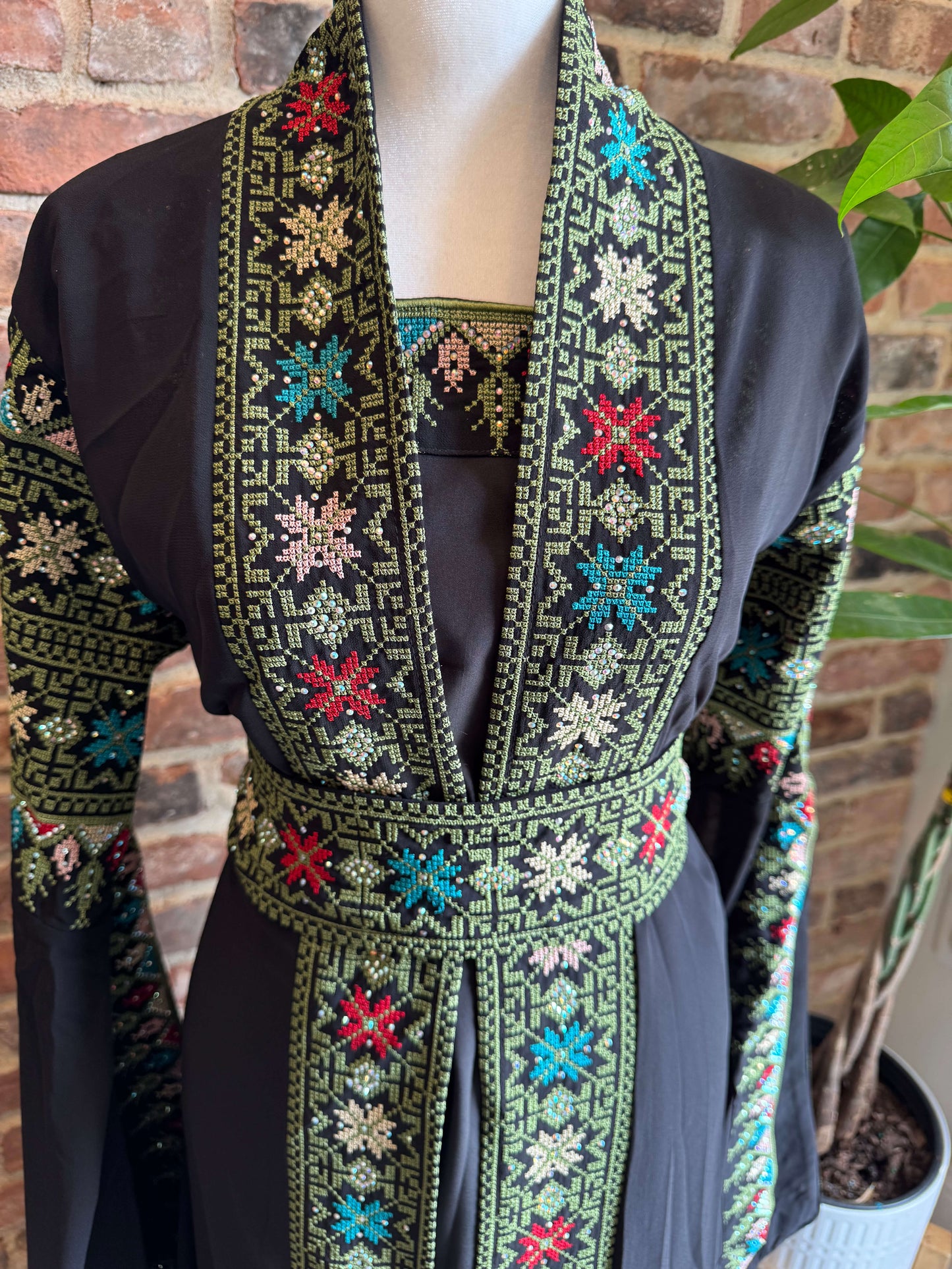 Close-up of green embroidery on the front of black luxury abaya set – elegant detail for modest Arab fashion in the USA