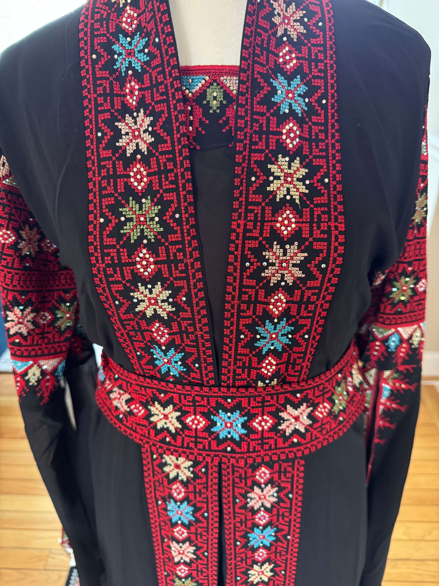 Close-up of red embroidery on the front of black luxury abaya set – detailed traditional design for modest fashion