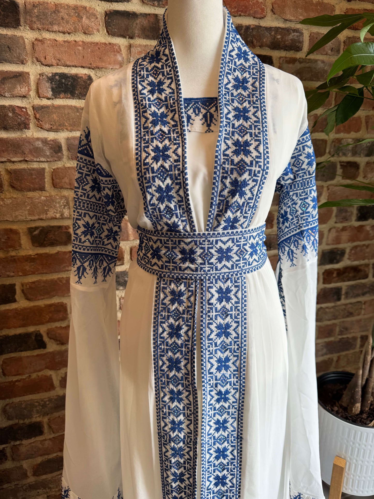 Close-up of blue embroidery on the front of white luxury abaya set – detailed Arab design for modest fashion