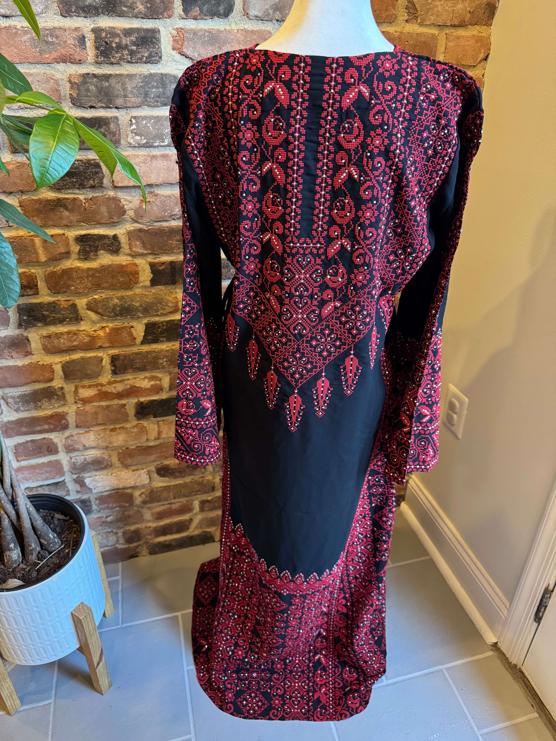 Back view of black Palestinian dress with red tatreez embroidery