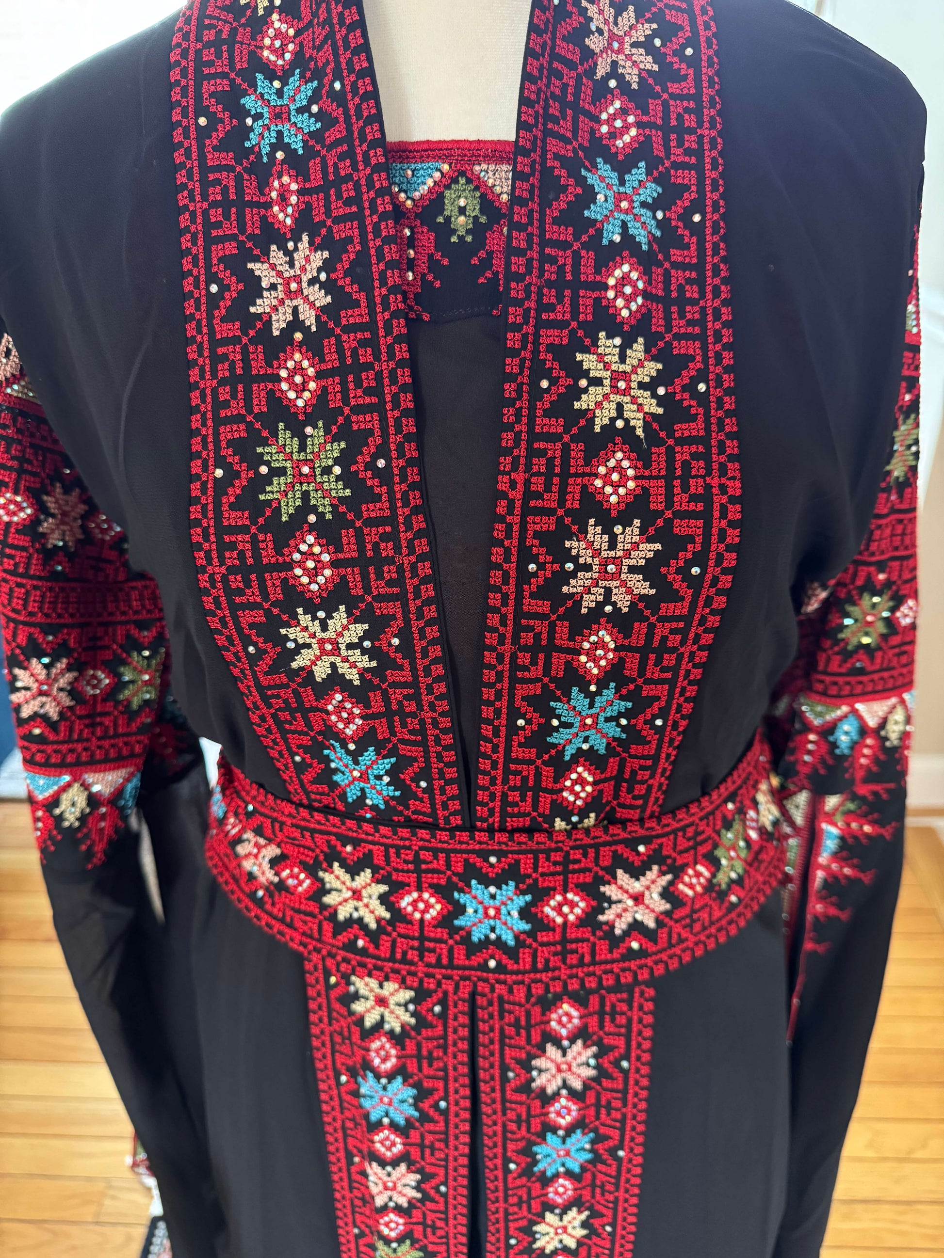 Close-up of red embroidery on the front of black luxury abaya set – detailed traditional design for modest fashion